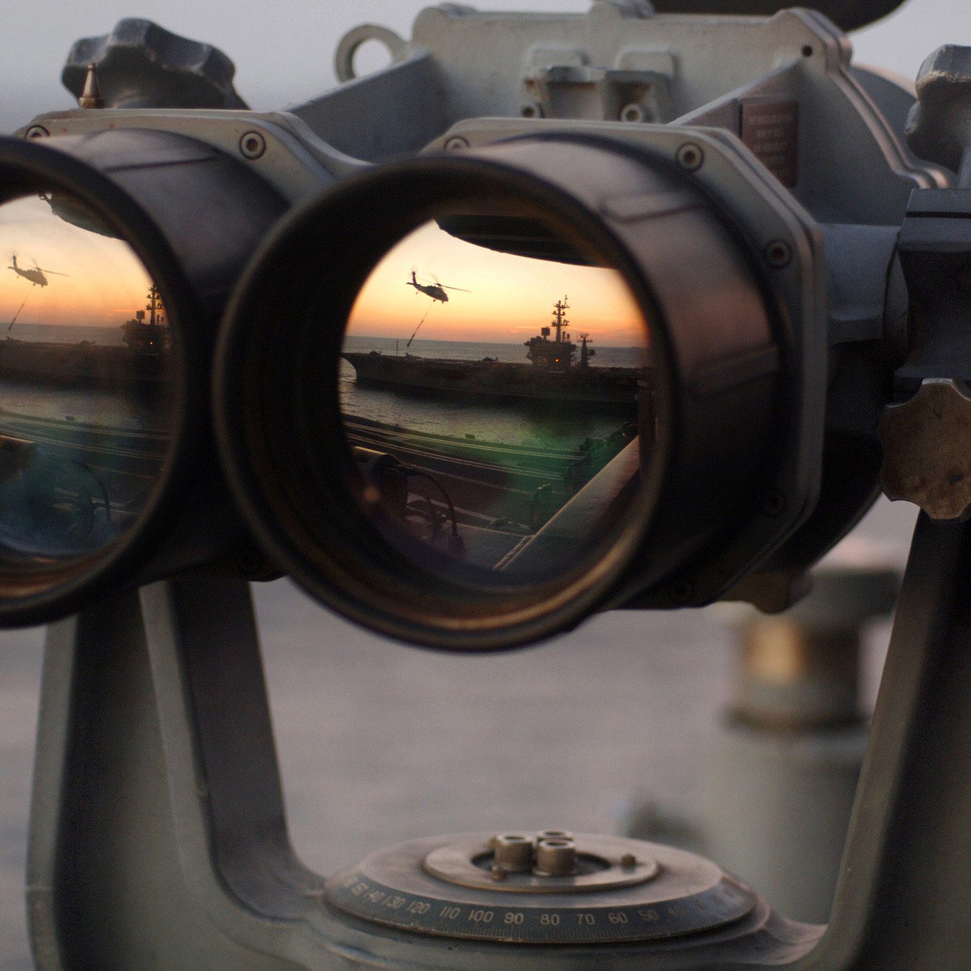 051104-N-2984R-004
Onboard USS Harry S. Truman
The sun sets over a set of "Big Eyes" binoculars on the signal bridge of the Nimitz-class aircraft carrier USS Harry S. Truman (CVN 75), while an MH-60 Knighthawk assigned to the "Bay Raiders" of Helicopter Combat Support Squadron (HSC) 28 airlifts several replenishment slings to USS Dwight D. Eisenhower (CVN 69).  USS Harry S. Truman is currently underway off the coast of the Eastern United States conducting replenishments at sea with USNS Arctic (T-AOE 8) and weapons offload operations with USS Enterprise (CVN 65) and USS Dwight D. Eisenhower (CVN 69). Harry S. Truman is scheduled to enter its Docked-Planned Incremental Availability at the beginning of 2006. US Navy photo by Photographer's Mate Airman Ricardo J. Reyes.  (Released by HST Public Affairs.)